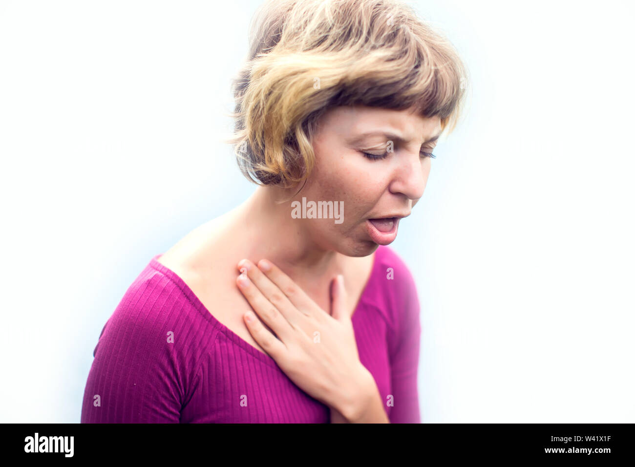 Throat Pain. Ill Woman Suffering From Painful Swallowing, Touching Neck With Hand. Female Caught Cold. Healthcare, people and medicine Concept. Stock Photo