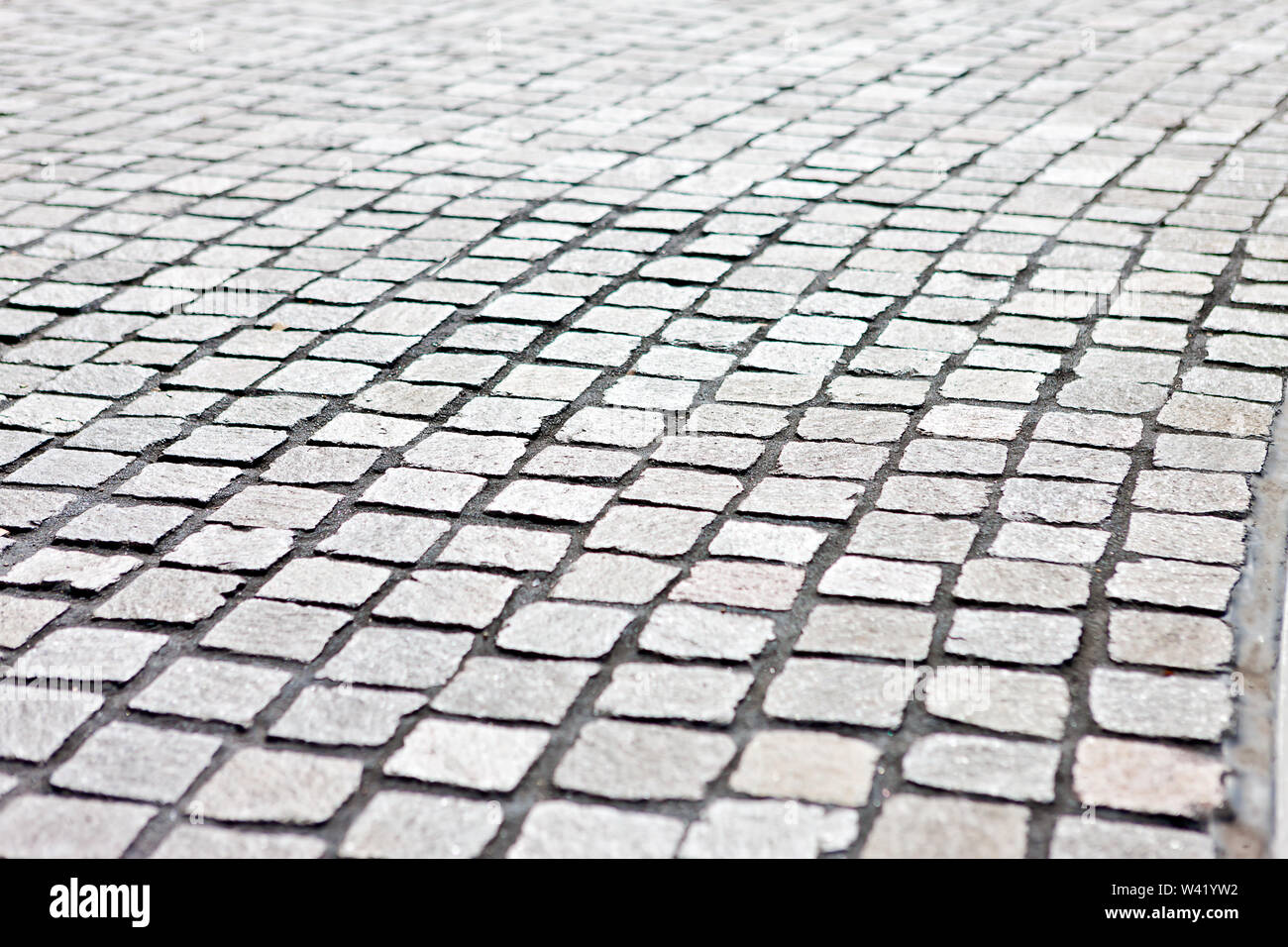 Closeup of a modern and empty detailed stone tile street with square