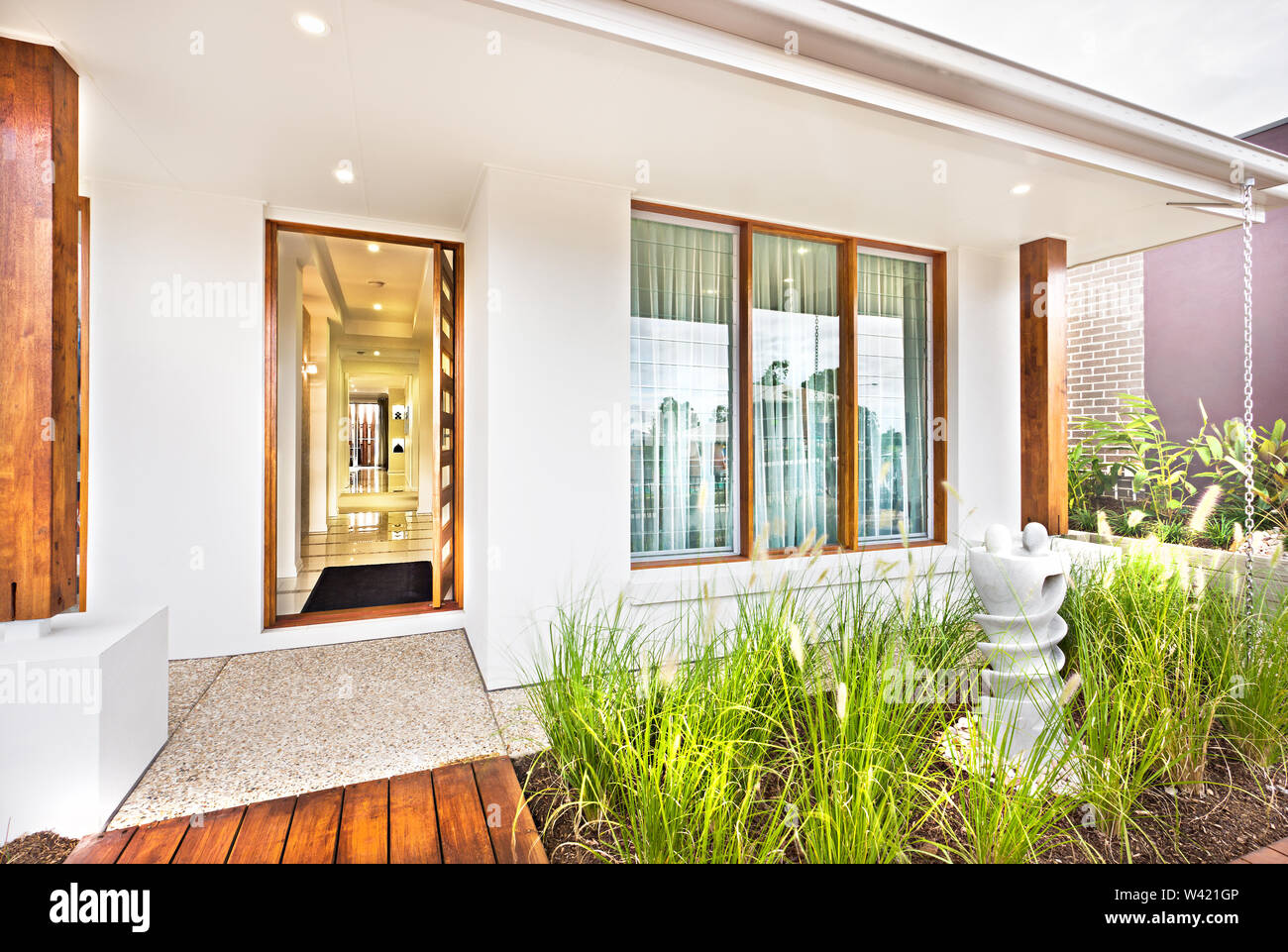 Modern house entrance with wooden door and concrete floor with a grass ...