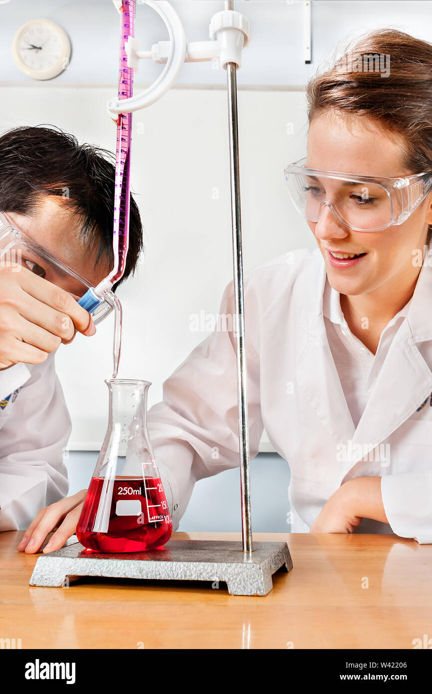 Lab partners do experiments with science equipments like beakers and