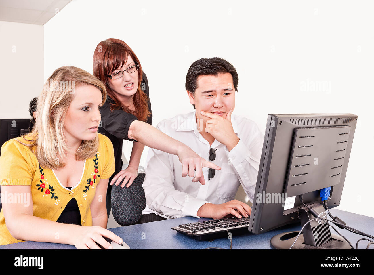 Girl shows a guy something on a computer screen in an office Stock Photo