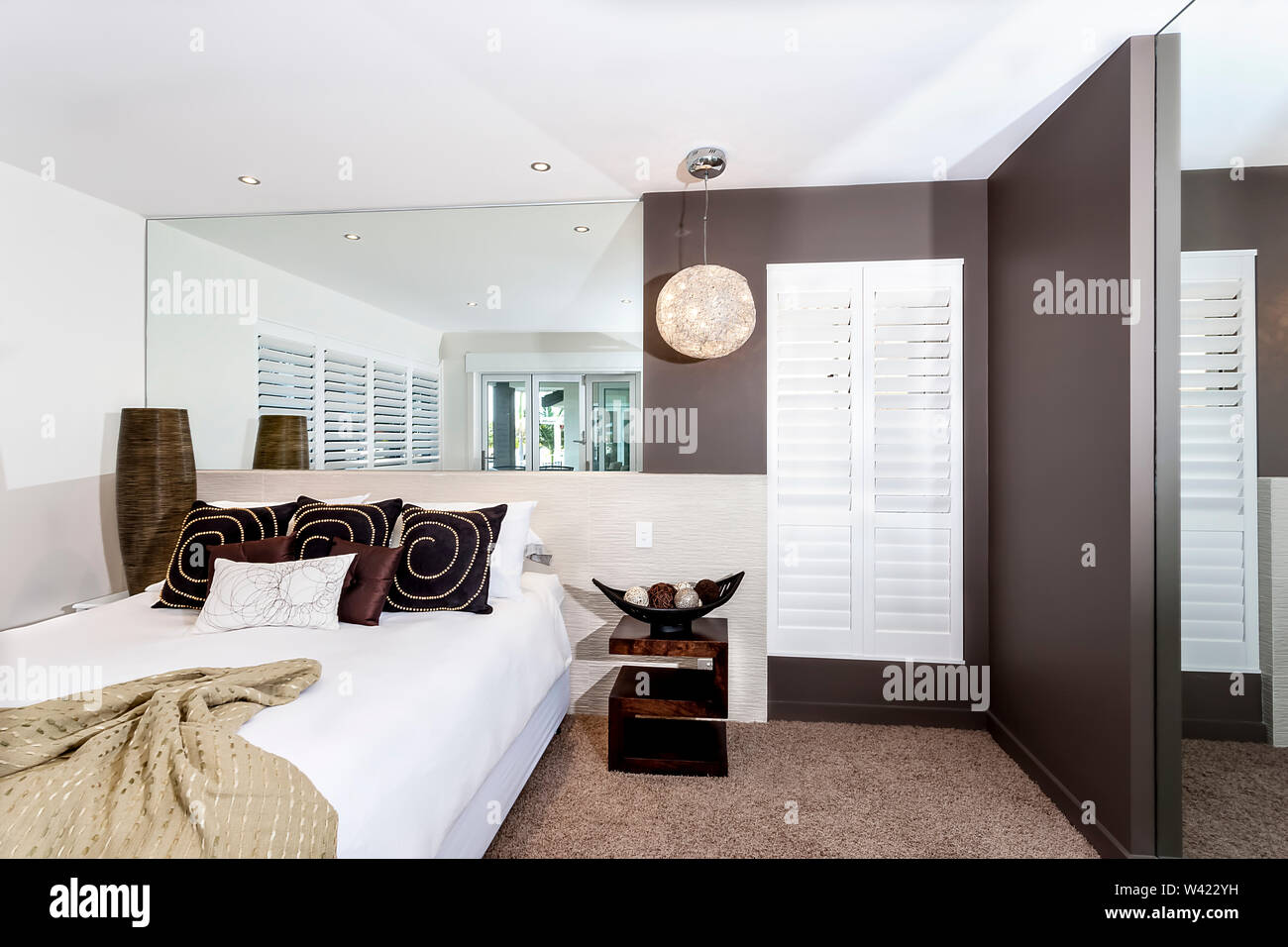 pix Big Mirror For Bedroom Wall https www alamy com modern bedroom with white sheets and pillows near a big mirror attached to the white wall image260660389 html