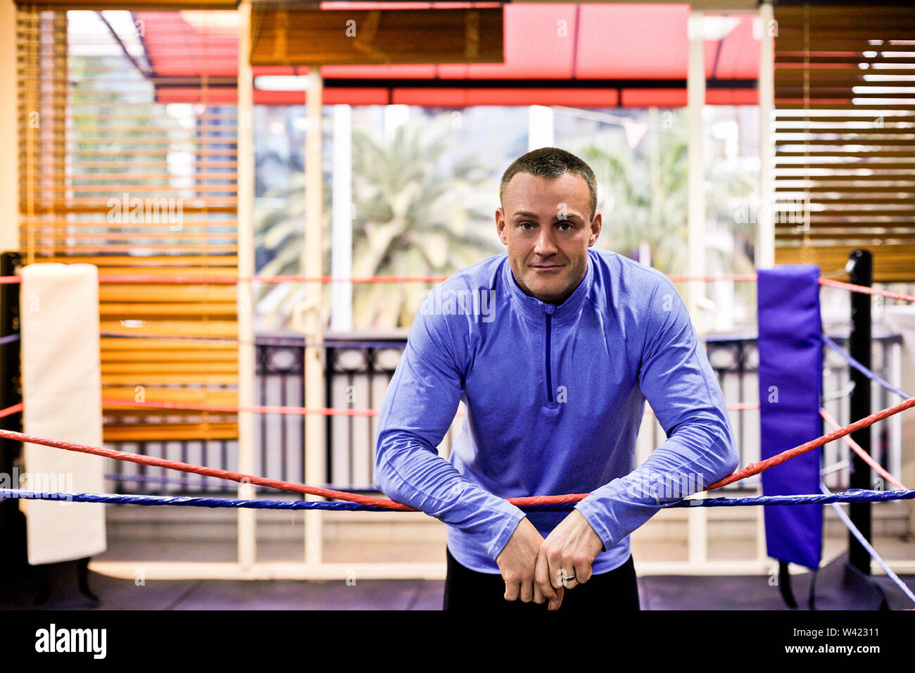 Fitness trainer standing in boxing area, inside room of a luxury gym ...
