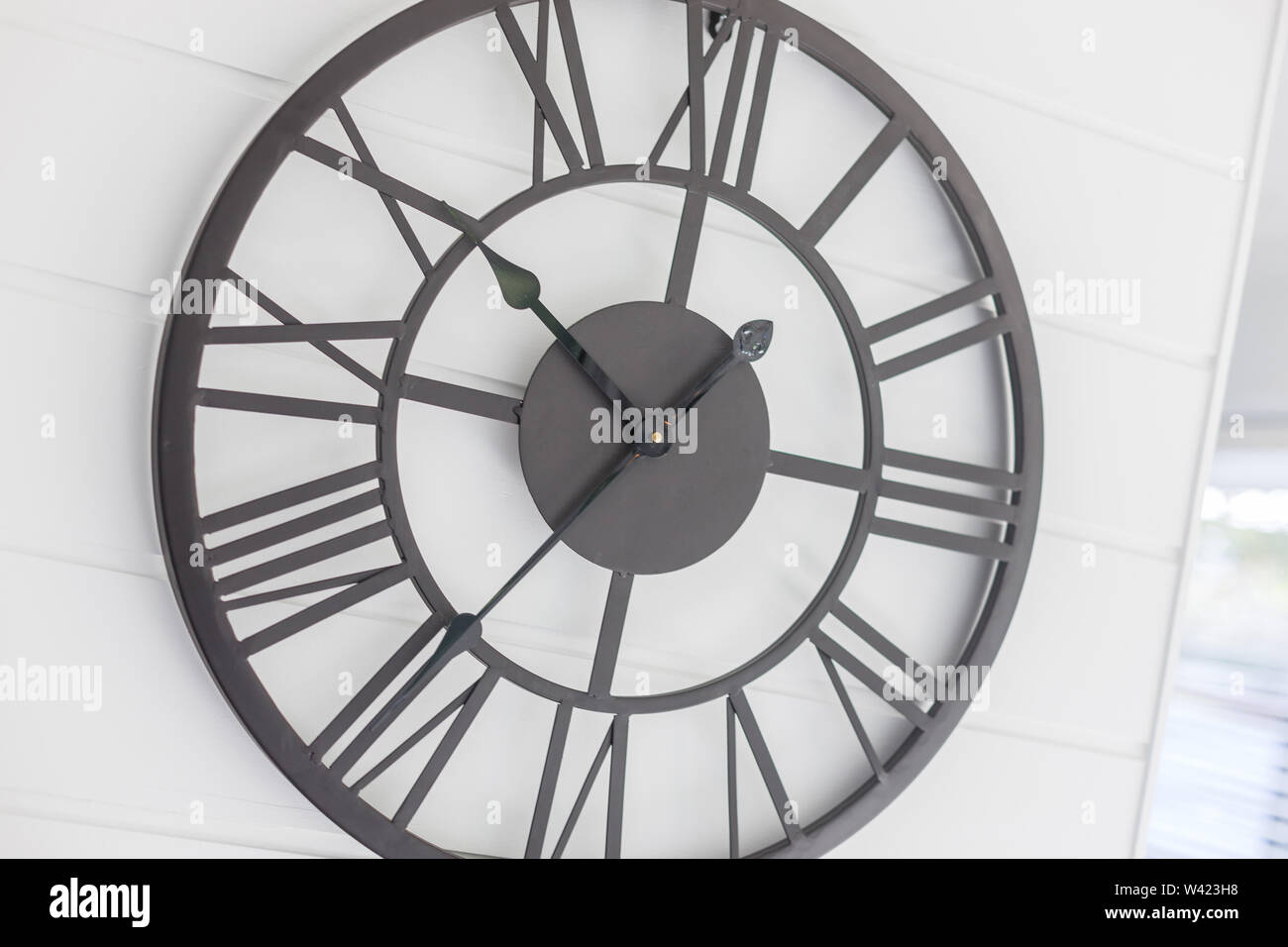 A tilted close up view of a contemporary style wall clock mounted