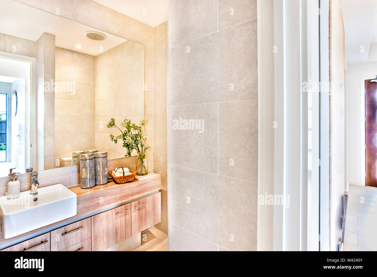 Modern washroom attached to the hallway entrance with sunlight, white