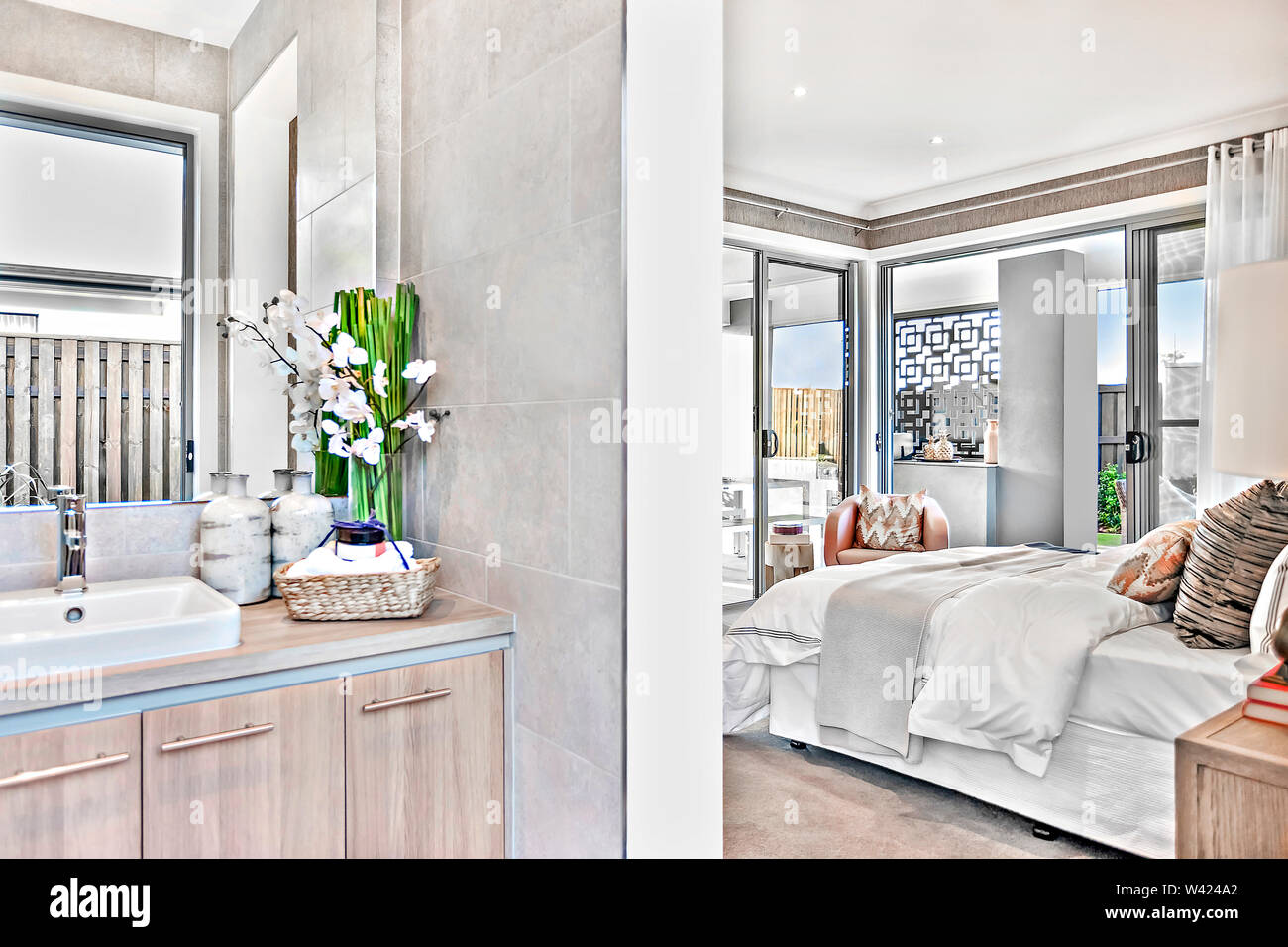 Modern Washroom Attached To The Bedroom In A Luxury House With A Master Bed And Sheets Beside Open Door And Windows To The Outside Stock Photo Alamy