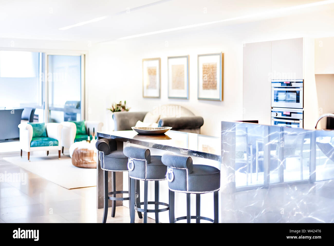 Modern Kitchen And Dining Room Illuminated By Sunlight Beside The Dining Area That Blared From The Behind The Oven In The Pantry Cupboard Wall Behind Stock Photo Alamy
