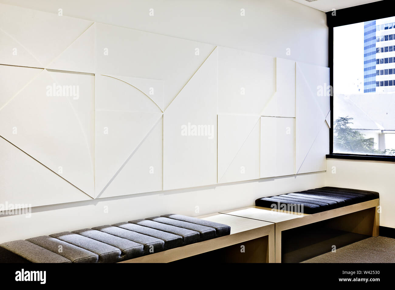 Modern relaxes or waiting room close view with cushion benches and wall