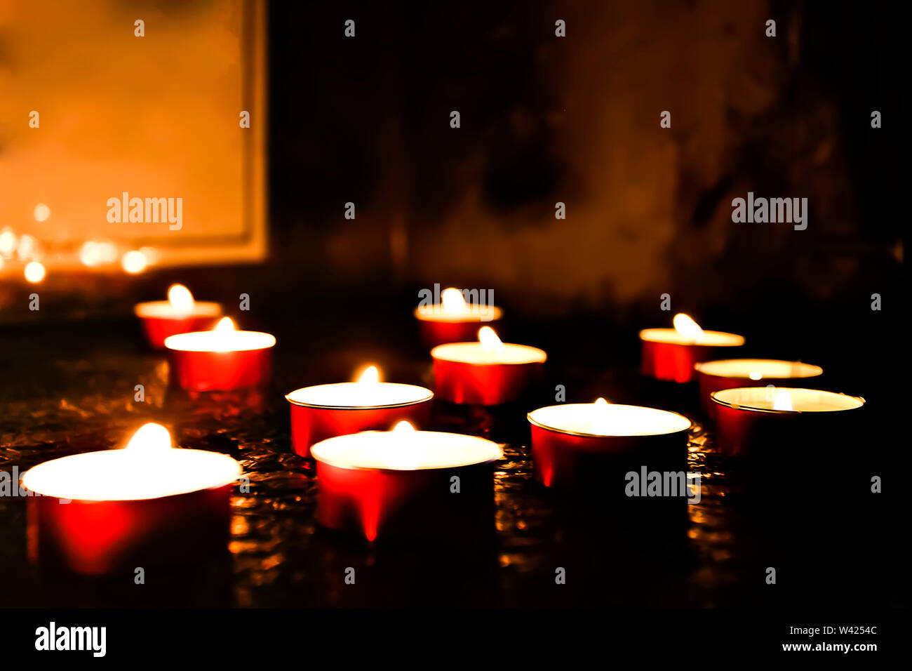 hiny burning candle in a dark room with low light Stock Photo Alamy