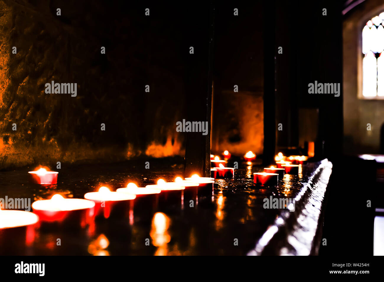 Shiny candle in dark room with reflection on walls Stock Photo Alamy