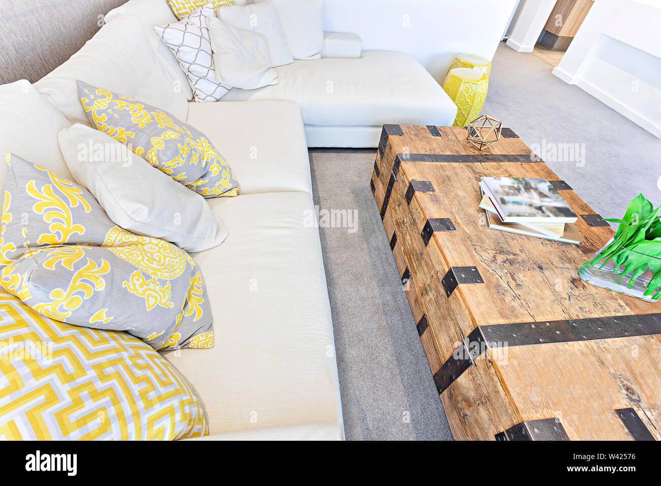 Pillows On A White Sofa With A Wooden Table Box Some Books And