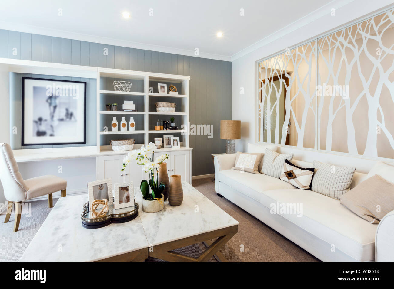 A Blending Dcor With Shades Of White And Ochre In The Living Room White Sofa And White Showcase With A Designer Glass Partition Stock Photo Alamy