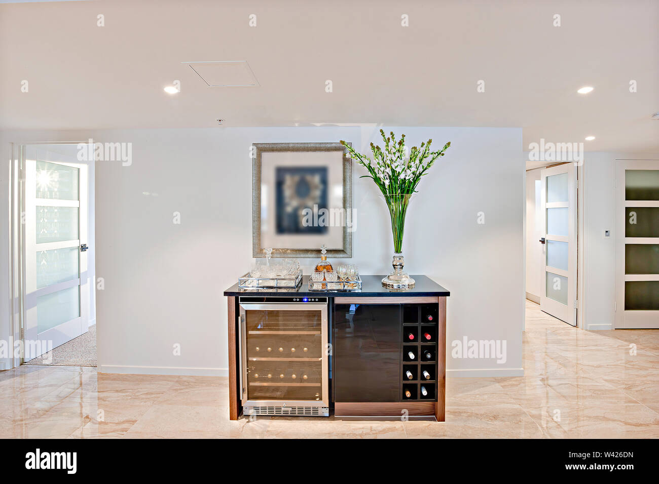 A modern home bar with a beer chiller, a wine rack, and barware Stock