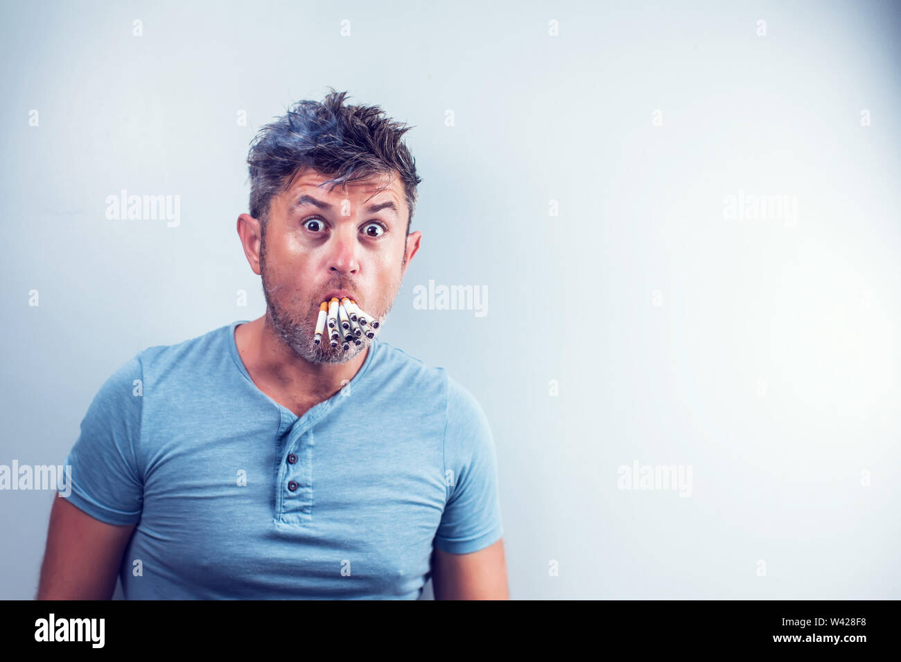 Young man with many cigarettes in his mouth Stock Photo