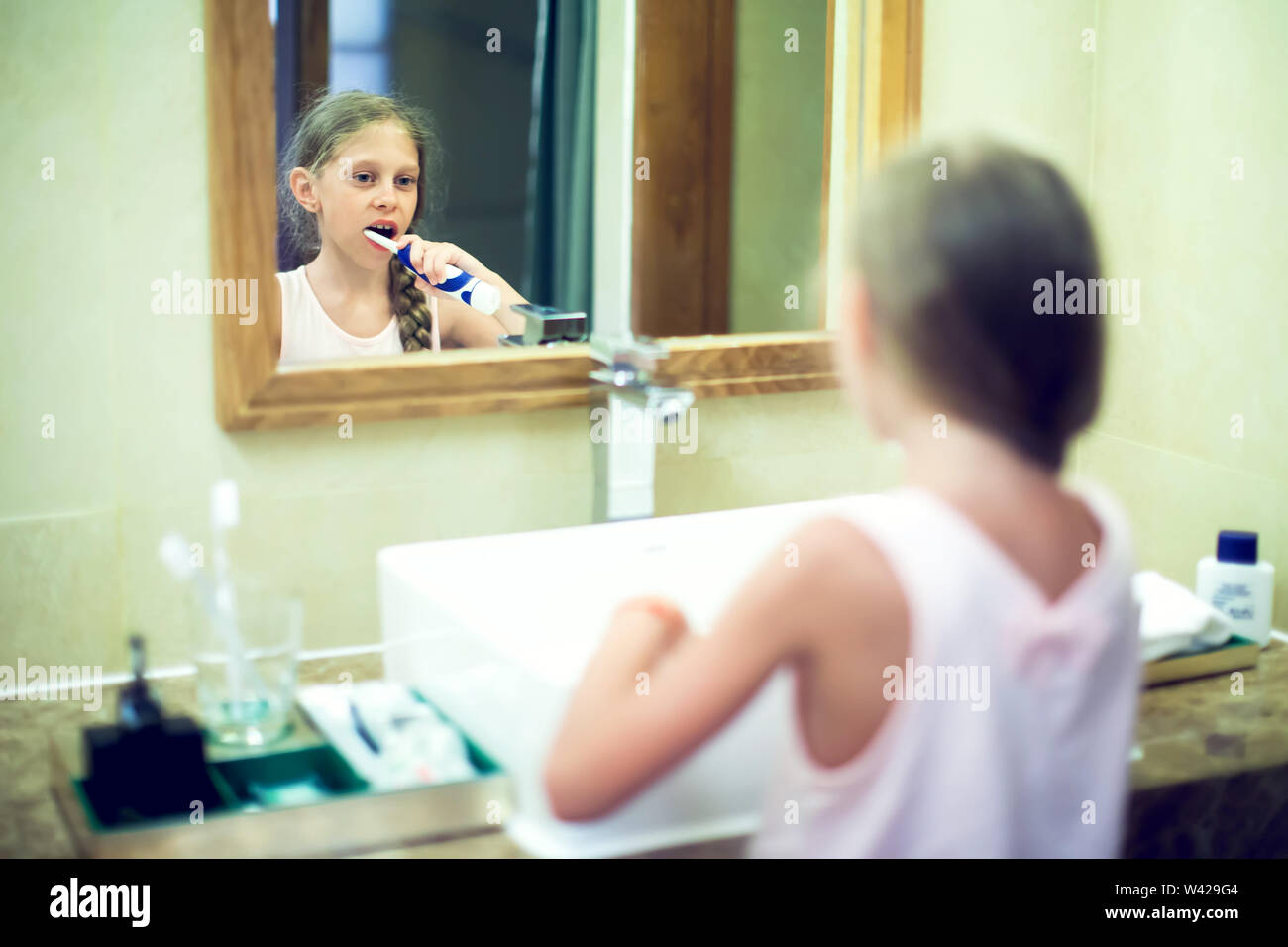 Smiling cute little girl brushing teeth in bathroom. Hygiene concept Stock Photo