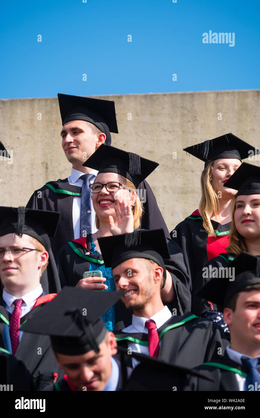 Higher education in the UK - successful students at the graduation ceremony at Aberystwyth university, after receiving their degrees, wearing their traditional caps and gowns. July 2019 Stock Photo