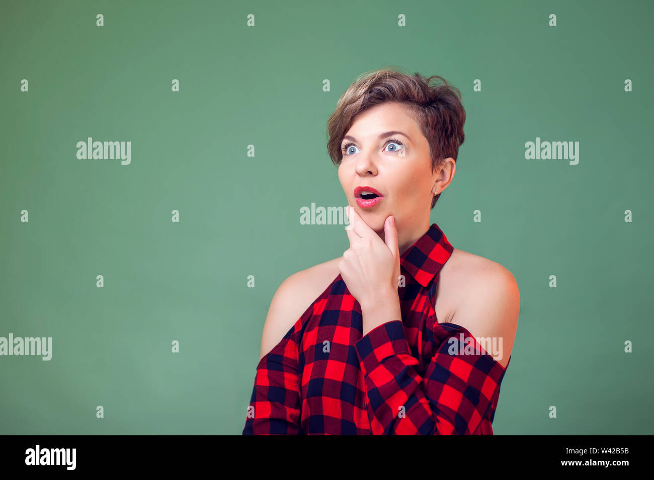 People and emotions - a portrait of surprised young woman with short dark hair Stock Photo