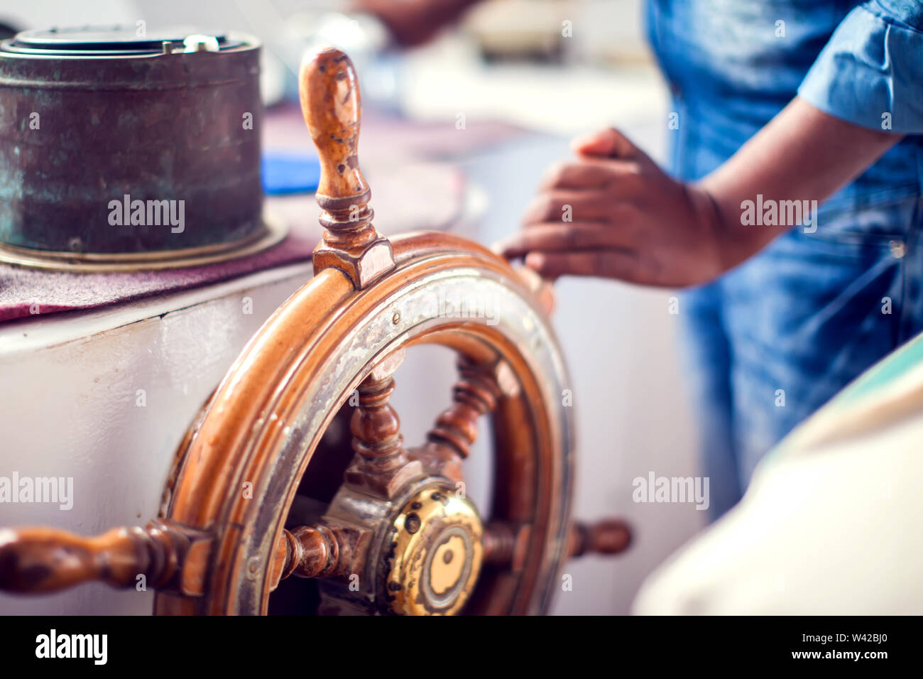 The hands of the captain and a steering wheel boat port services Stock Photo