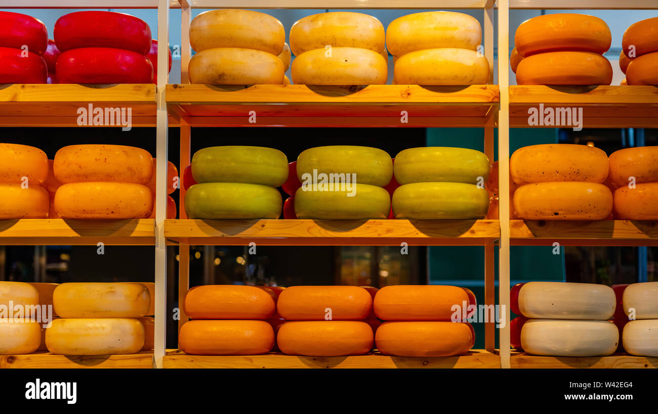 Dutch cheeses, edam, gouda, whole round wheels on wooden shelf, cheese