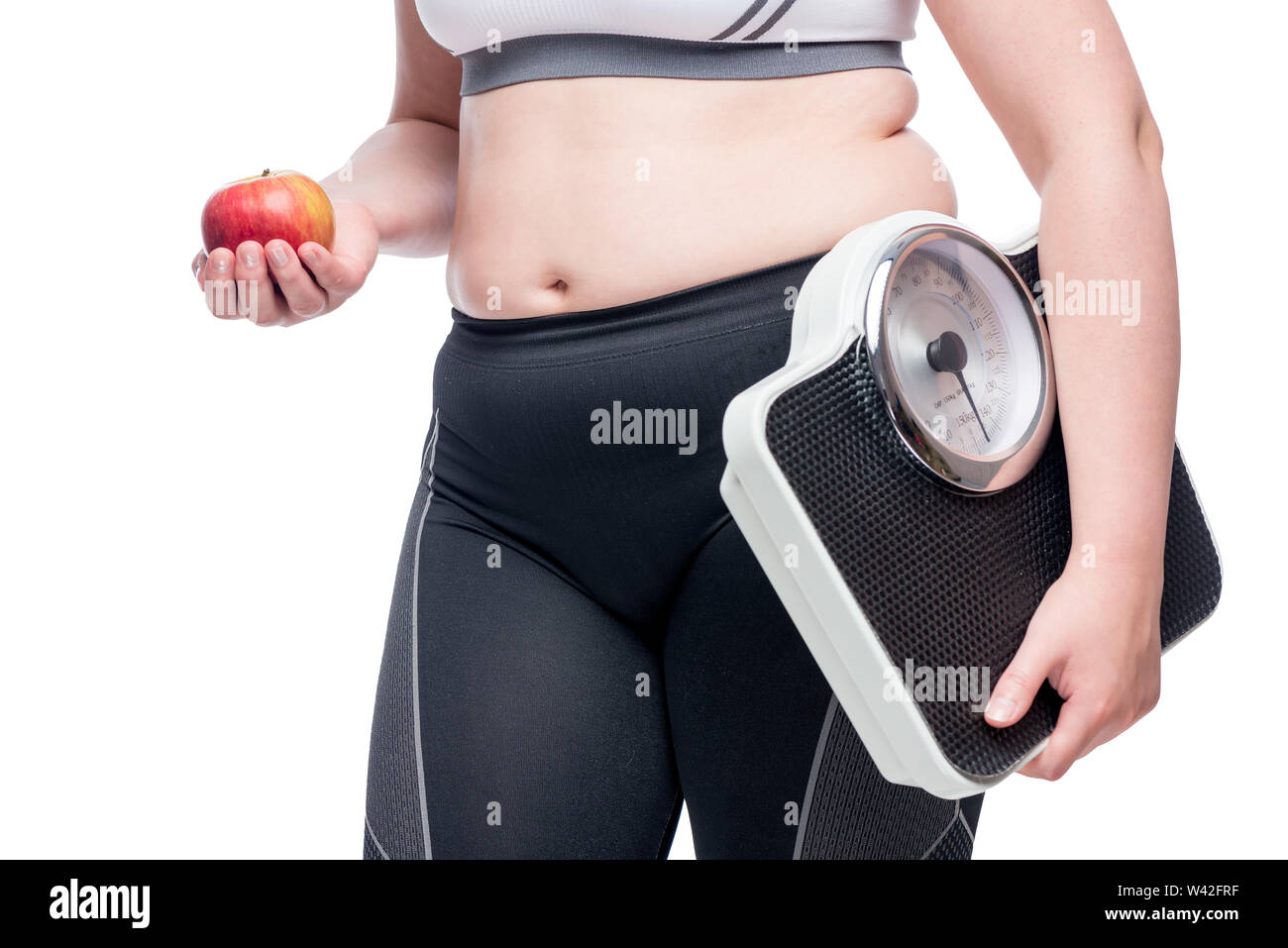 woman with scales and apple makes a choice in favor of sports and healthy eating concept photo