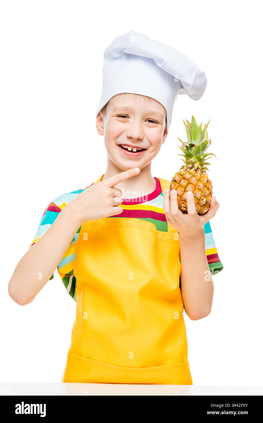 little cook in a cap with a mini pineapple on a white background in an apron Stock Photo