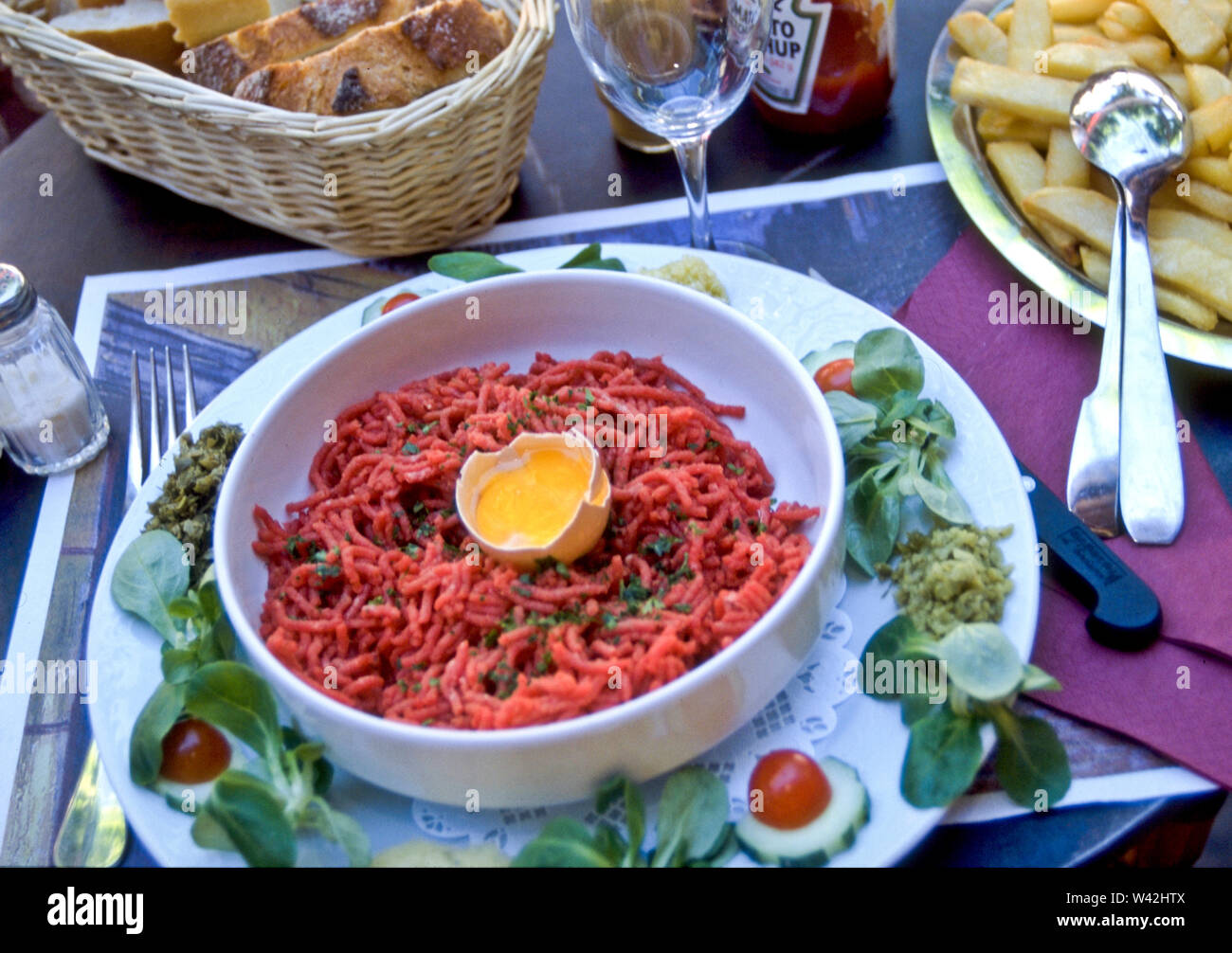 Steak Tartare is a meat dish made of ground or minced meat served with onions, capers, Worchestire sauce and others, topped with a raw egg. Stock Photo