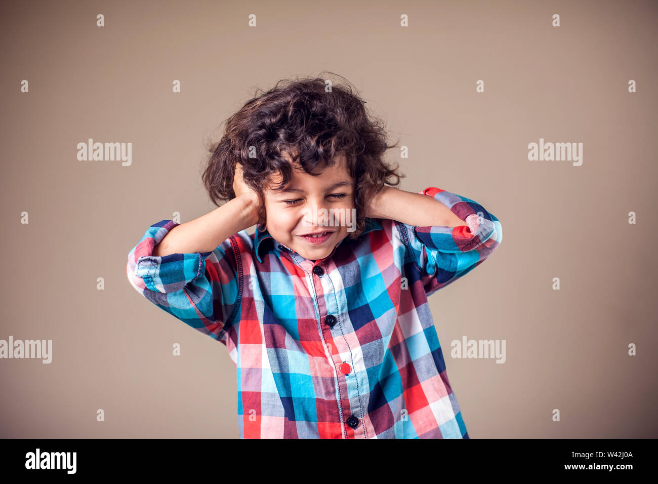 Young boy with covering his ears with hands.Children and emotions concept Stock Photo
