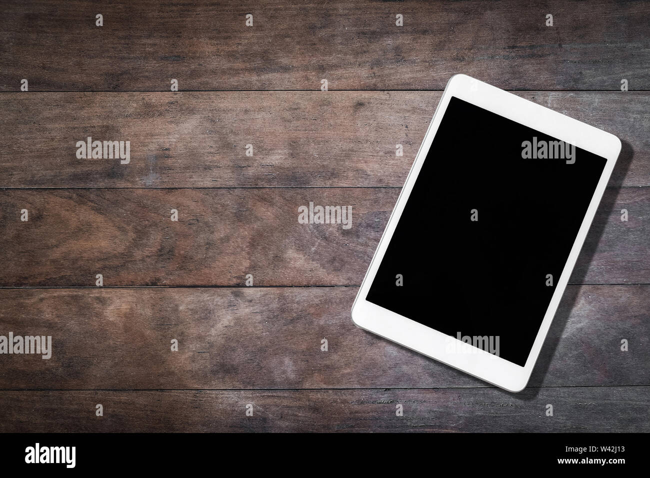white tablet with blank screen on wooden table Stock Photo