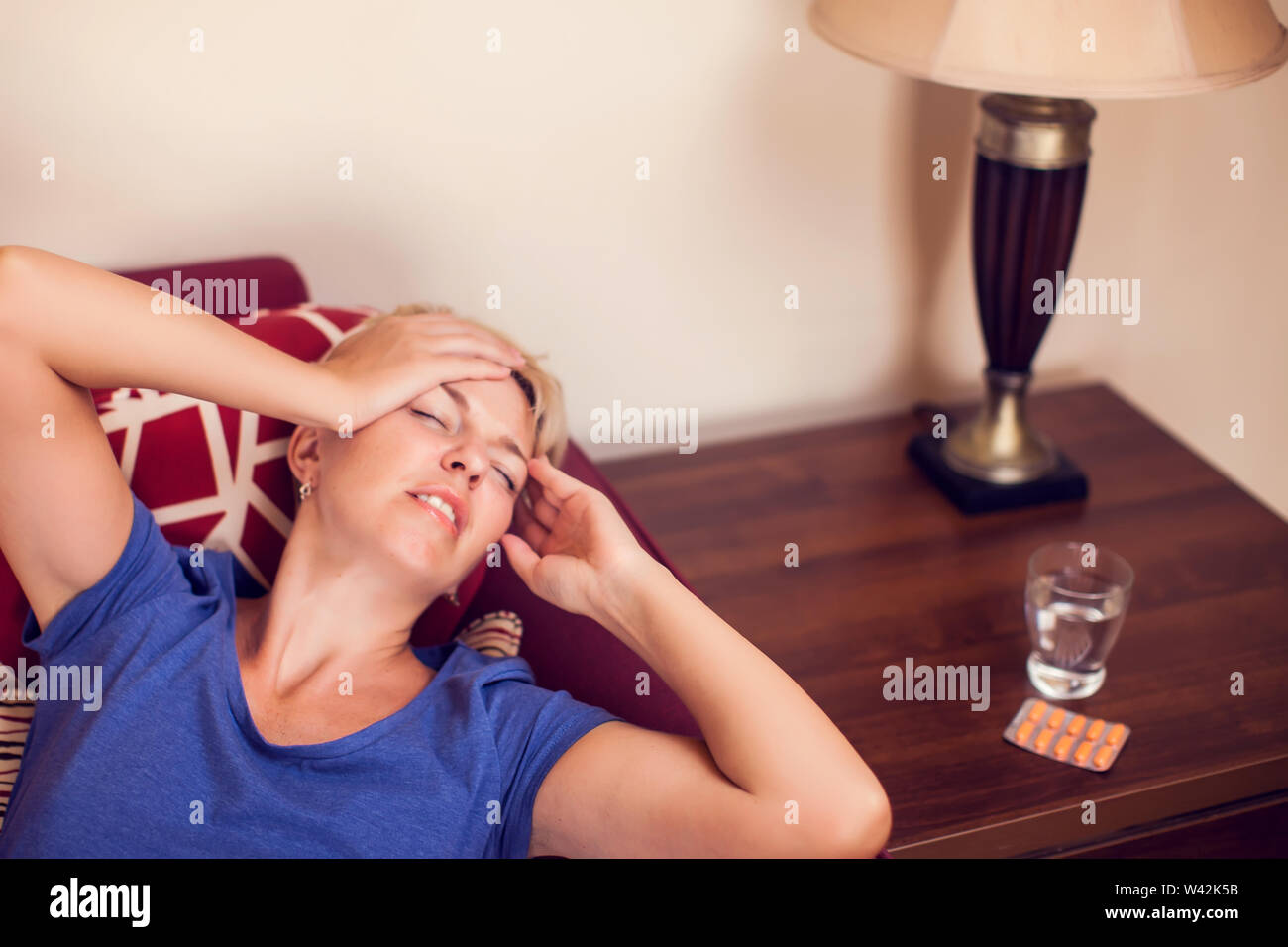 Woman feels strong headache at home. People, healthcare and medicine concept Stock Photo