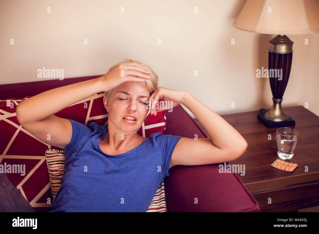 Woman feels strong headache at home. People, healthcare and medicine concept Stock Photo