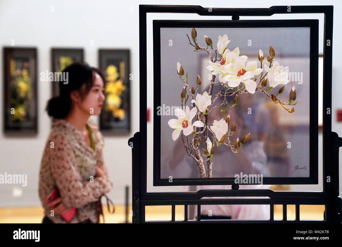 (190719) -- BEIJING, July 19, 2019 (Xinhua) -- People look at an exhibit during 'Splendid China -- Suzhou Embroidery Elaborate Art Works Exhibition' at the National Art Museum of China (NAMOC) in Beijing, capital of China, July 19, 2019. Opening here on Friday, the exhibition displays a rich collection of works by China's Suzhou embroidery masters in the contemporary era. (Xinhua/Jin Liangkuai) Stock Photo