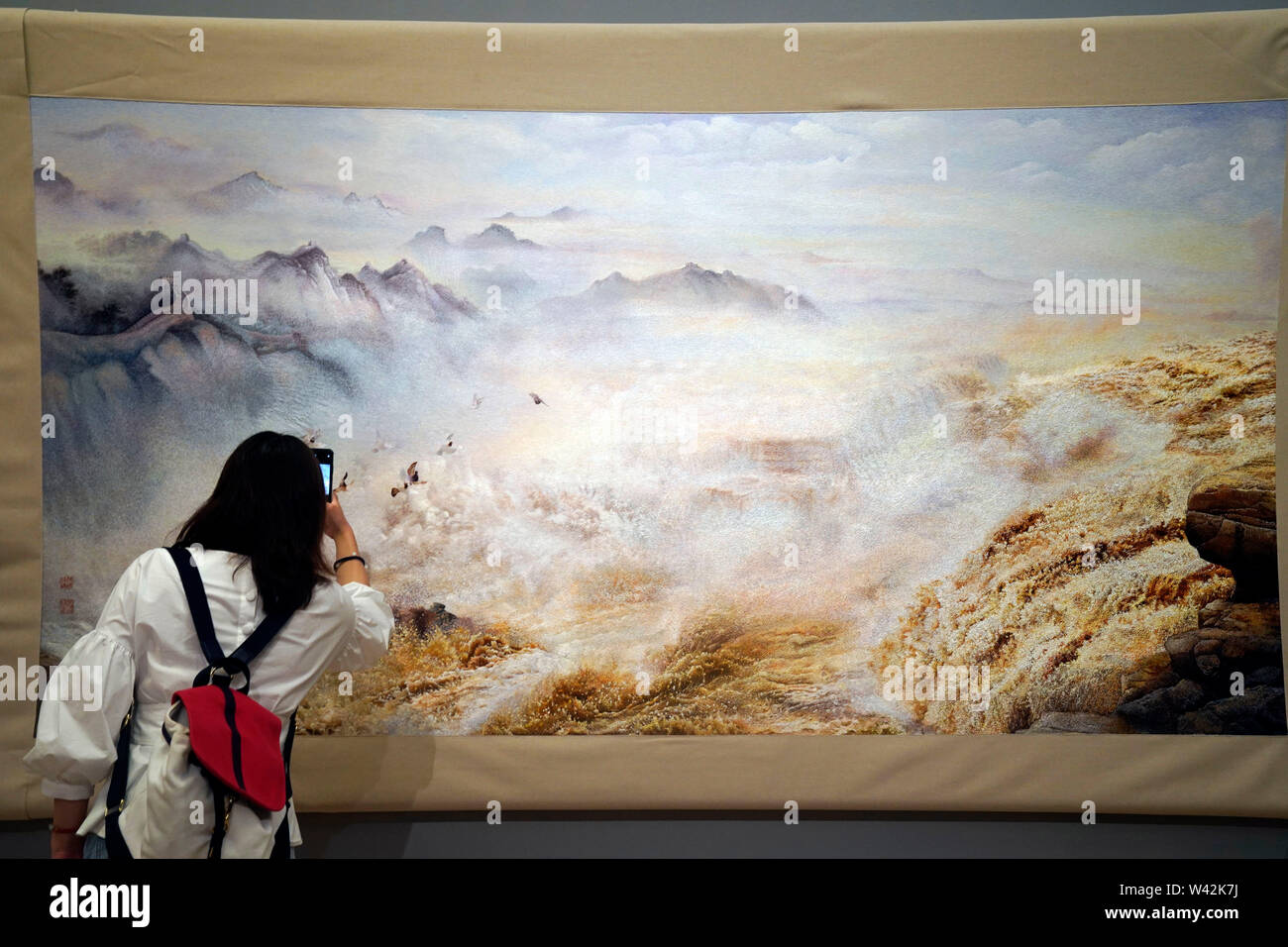 (190719) -- BEIJING, July 19, 2019 (Xinhua) -- A visitor takes photos of an exhibit during 'Splendid China -- Suzhou Embroidery Elaborate Art Works Exhibition' at the National Art Museum of China (NAMOC) in Beijing, capital of China, July 19, 2019. Opening here on Friday, the exhibition displays a rich collection of works by China's Suzhou embroidery masters in the contemporary era. (Xinhua/Jin Liangkuai) Stock Photo