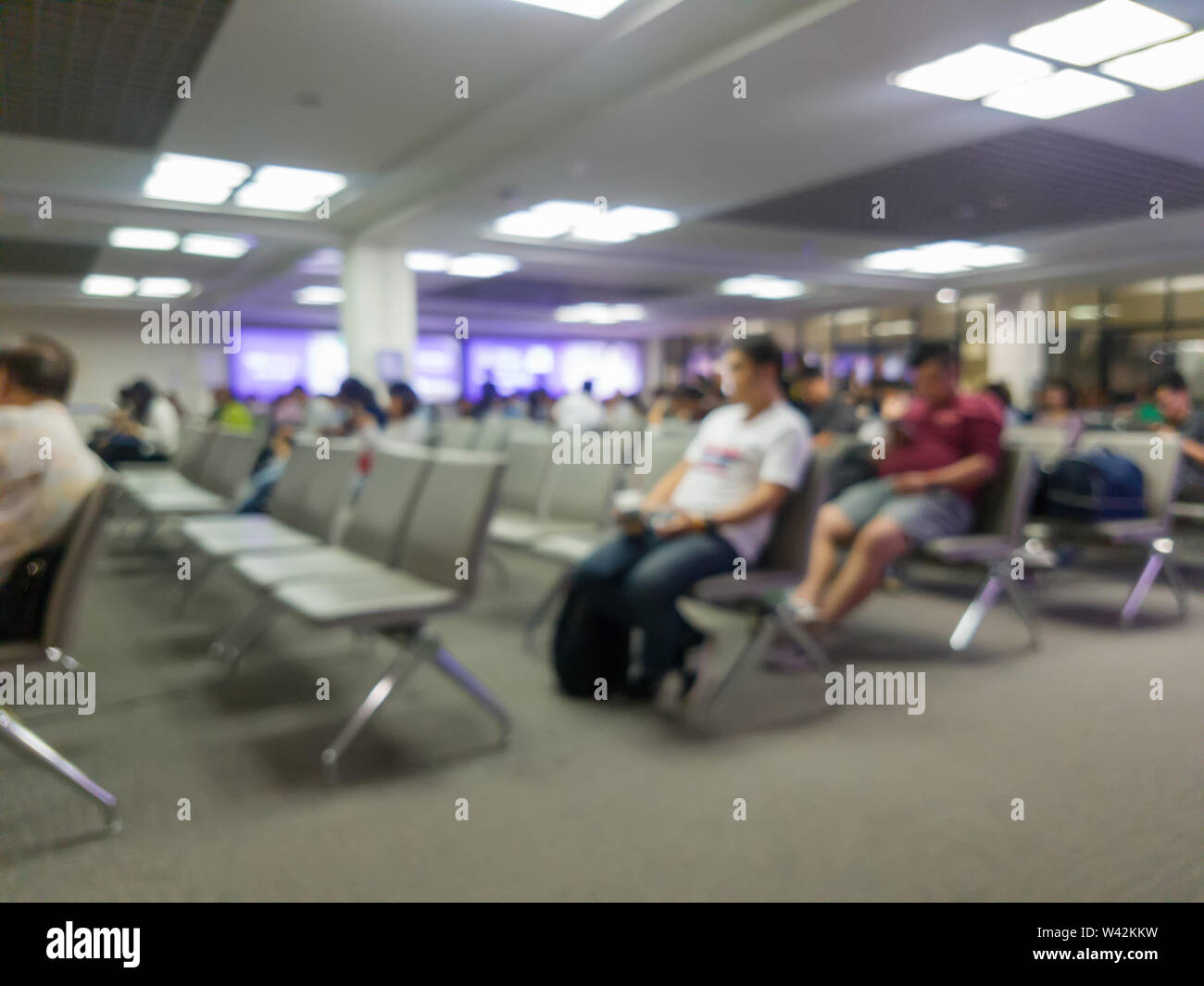 abstract blur of passengers sitting at the airport gate for waiting on boarding time Stock Photo