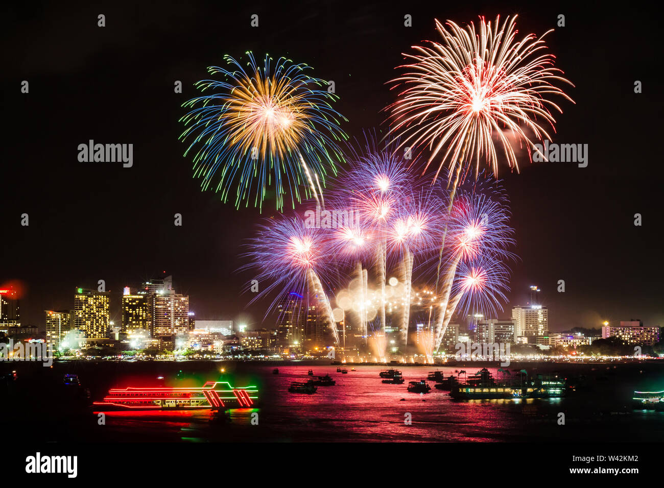 festive colorful firework light up the sky over the city at night scene for holiday festival and celebration background Stock Photo