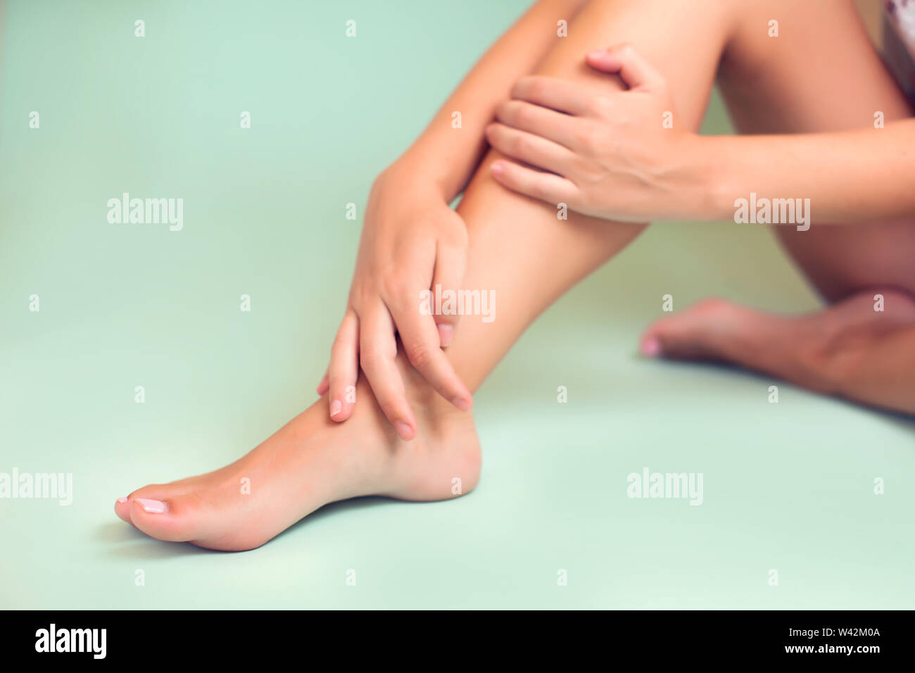 Woman feels strong foot pain isolated. People, healthcare and medicine concept Stock Photo