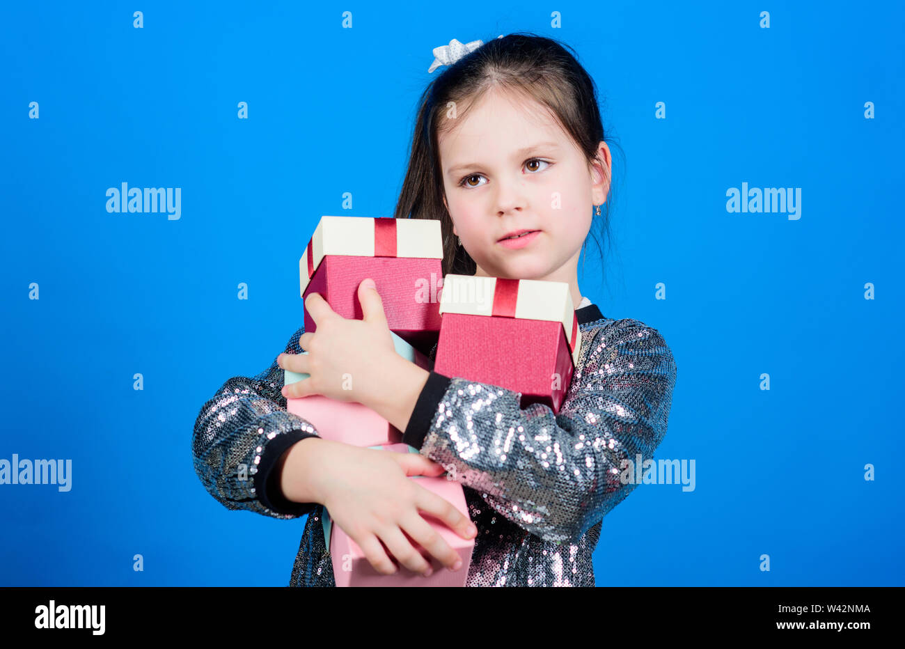 Shopping day. Child carry lot gift boxes. Kids fashion. Surprise gift box. Birthday wish list. Special happens every day. Shop for what you want. Girl with gift boxes blue background. Black friday. Stock Photo