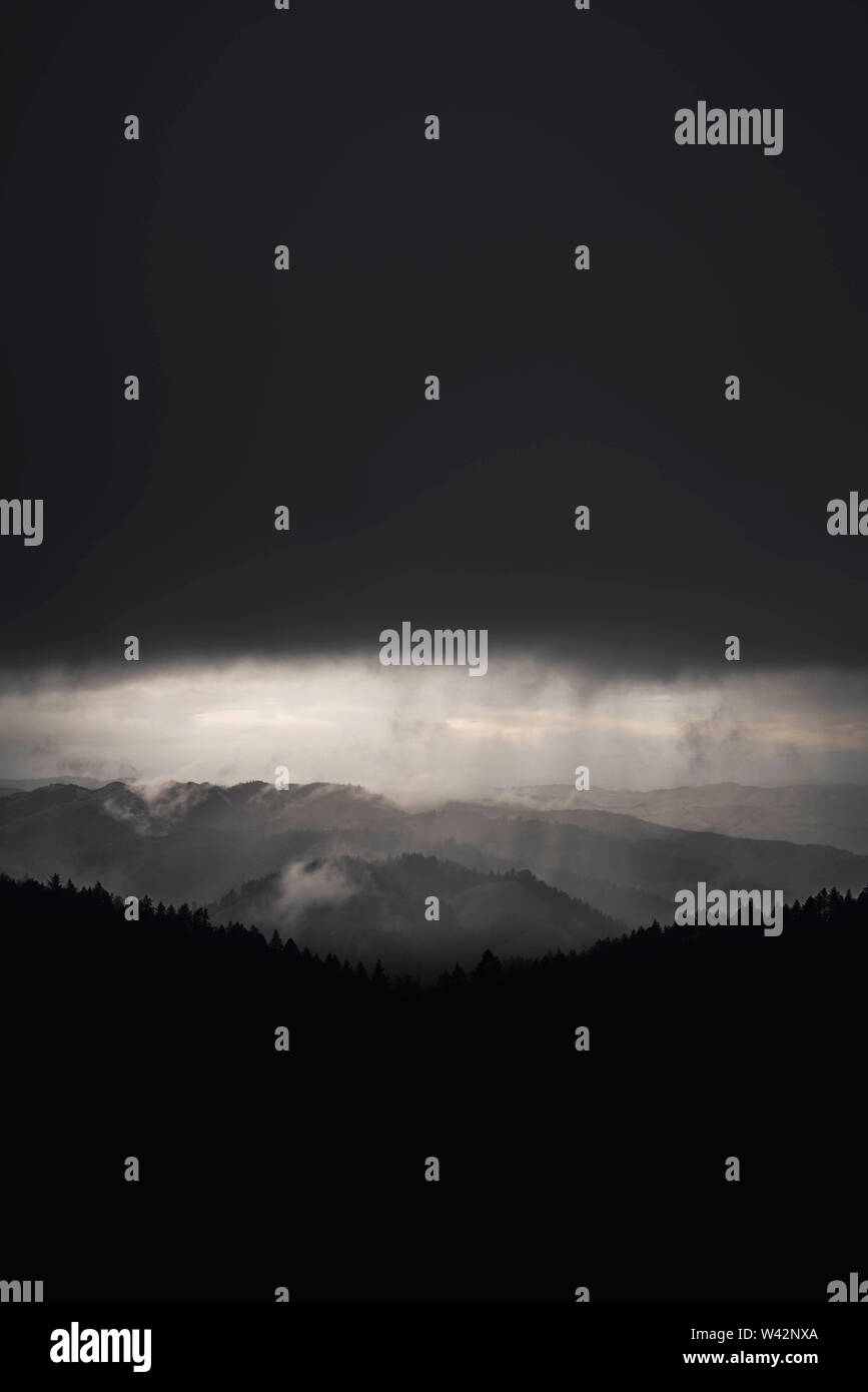 Dark storm cloud over hills and forest Stock Photo - Alamy