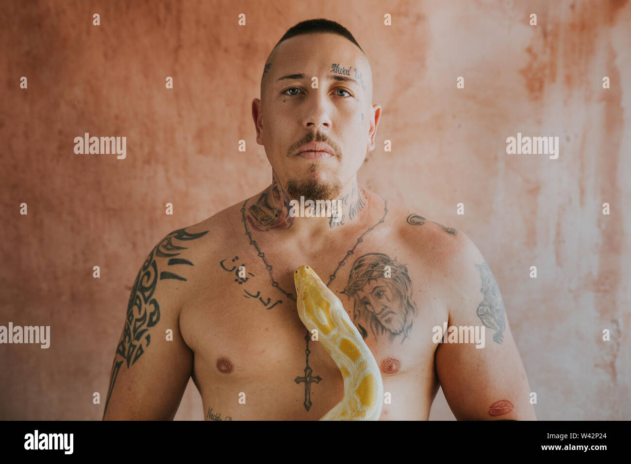 tattooed man looking at camera with a snake on his chest Stock Photo