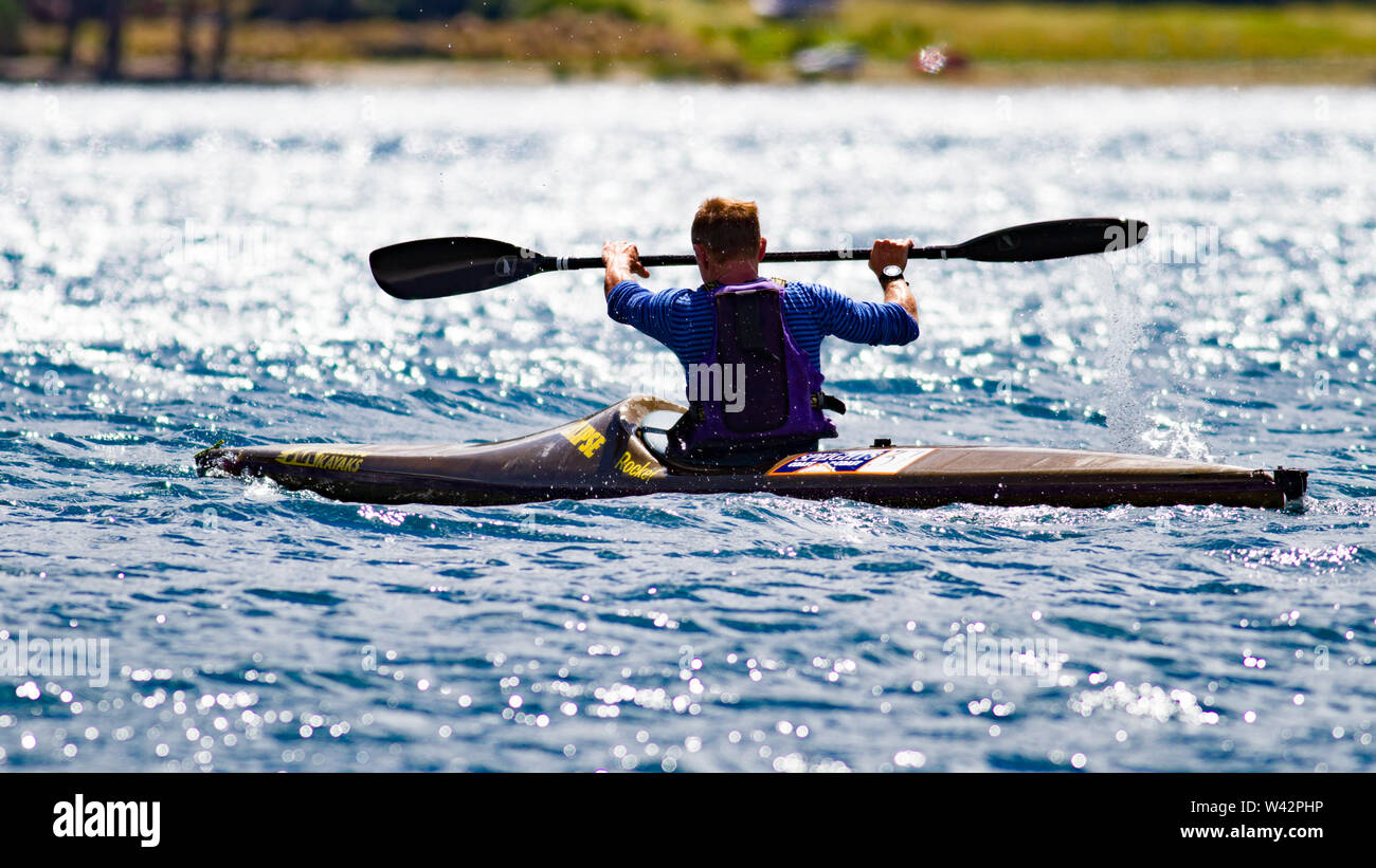 A kayak paddler powering through the waves Stock Photo