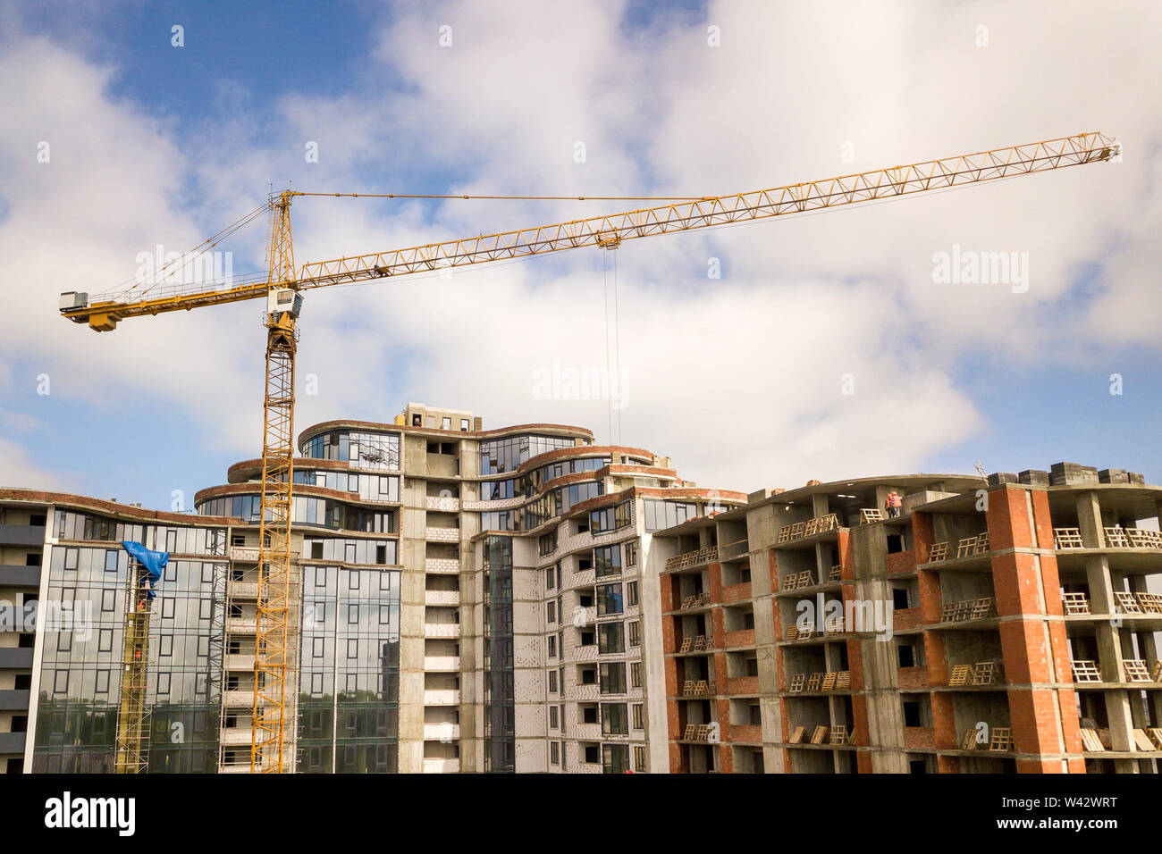 Apartment or office tall building under construction. Brick walls ...
