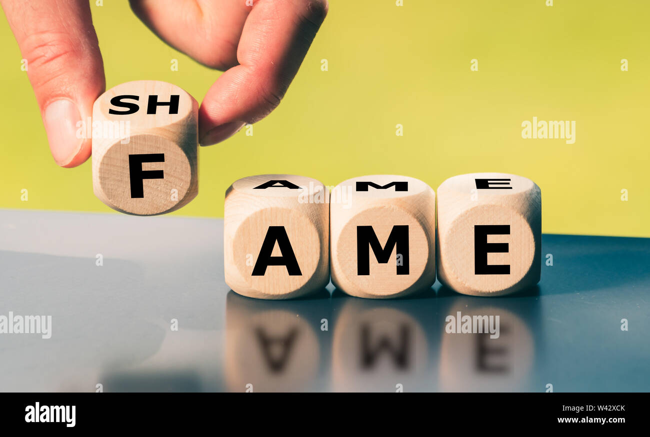 Hand turns a cube and changes the word "shame" to "fame Stock ...