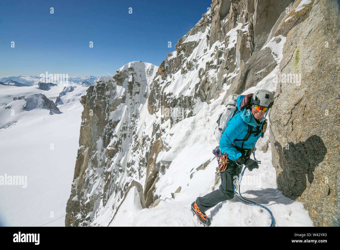 Woman alpinist smiling on a bluebird day in the French Alps Stock Photo
