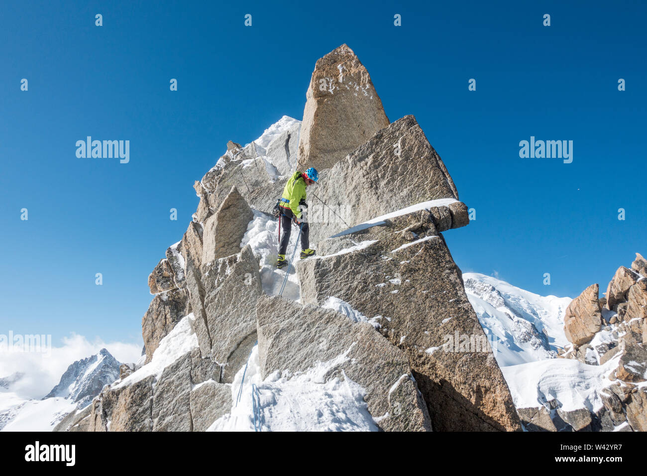 Alpinist rappels a short rock step on the Cosmiques Ridge Stock Photo