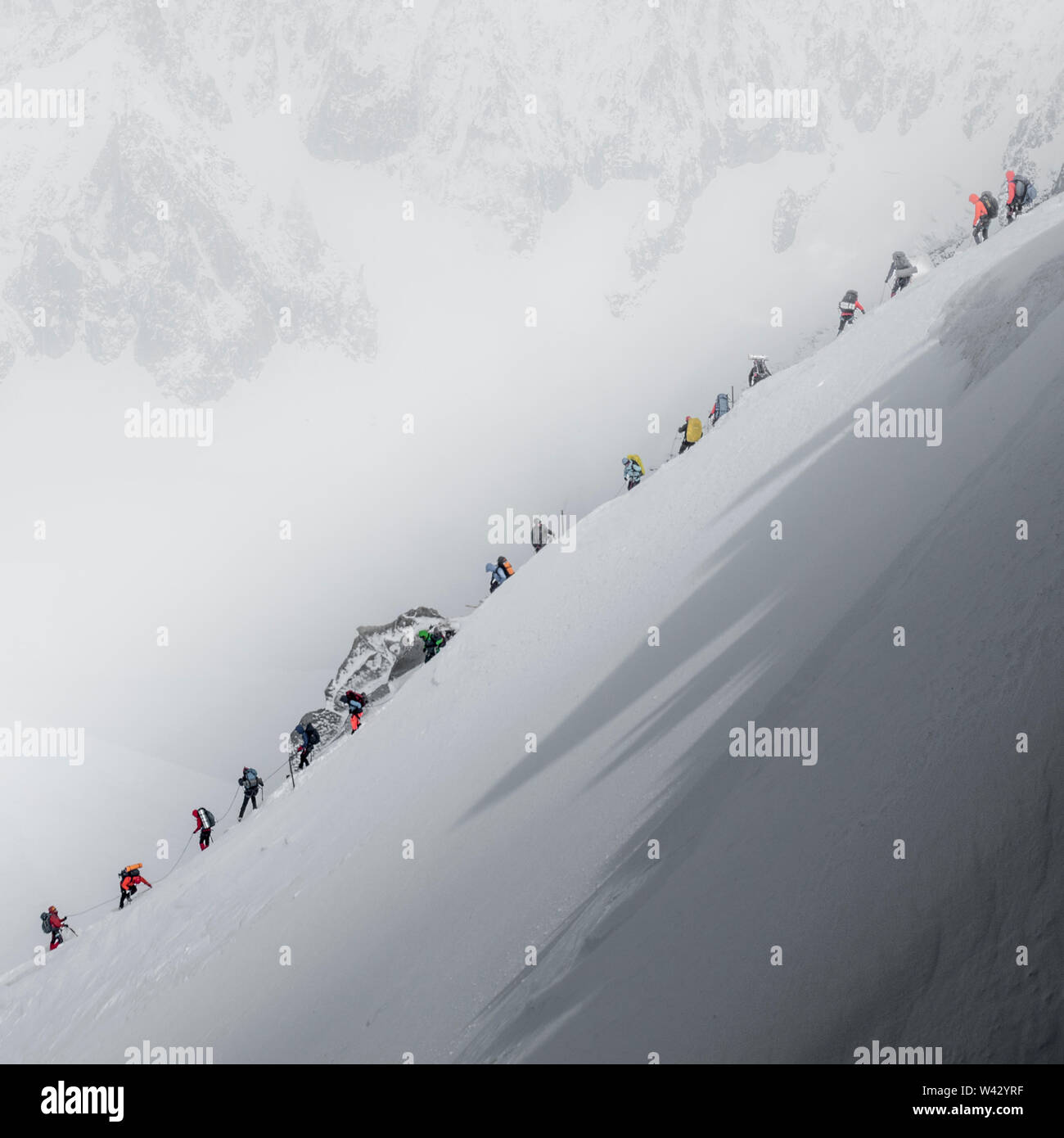 Traffic jam on Mt Blanc as a string of climbers navigate a steep ridge Stock Photo