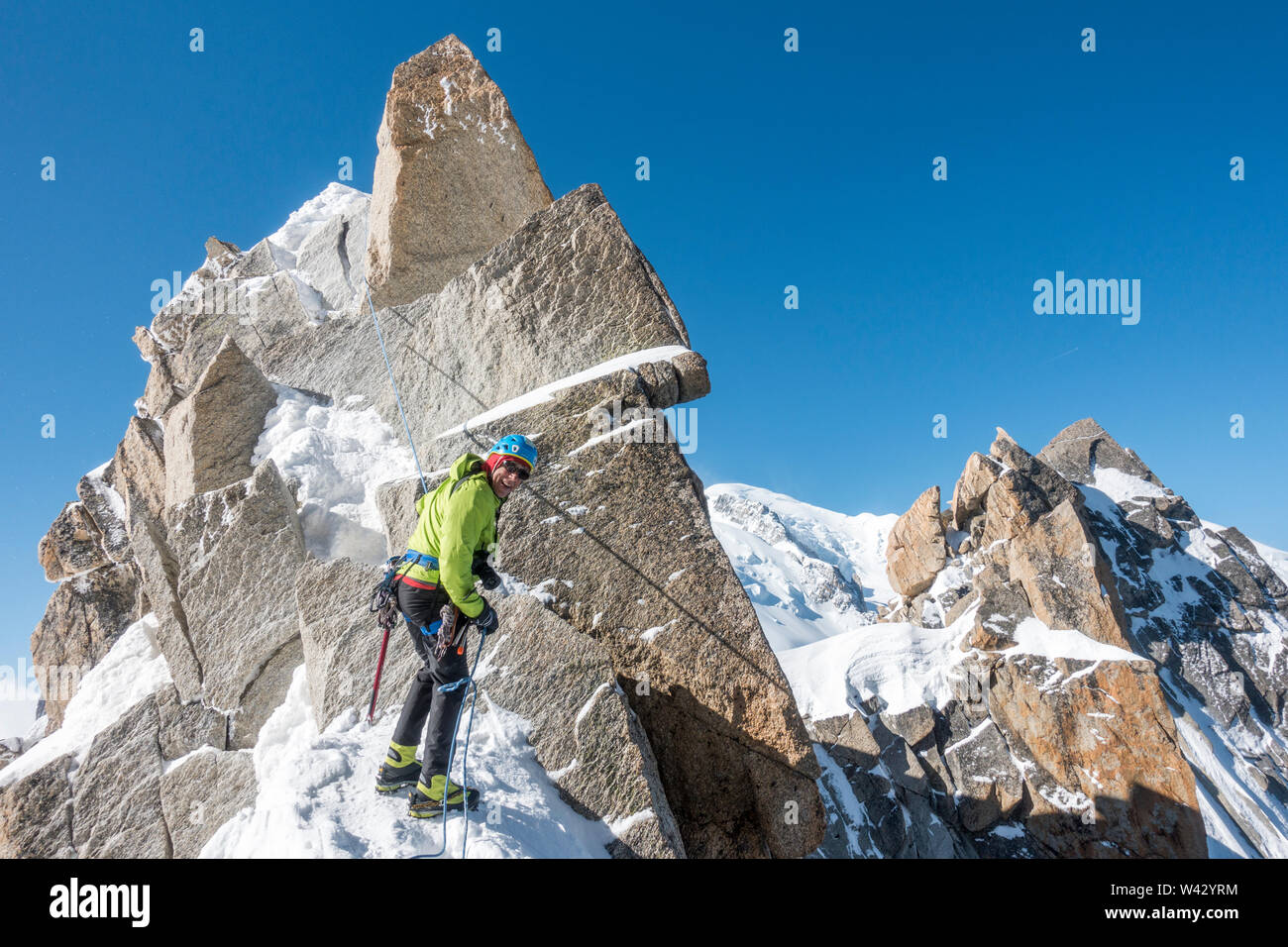 Alpinist rappels a short rock step on the Cosmiques Ridge Stock Photo