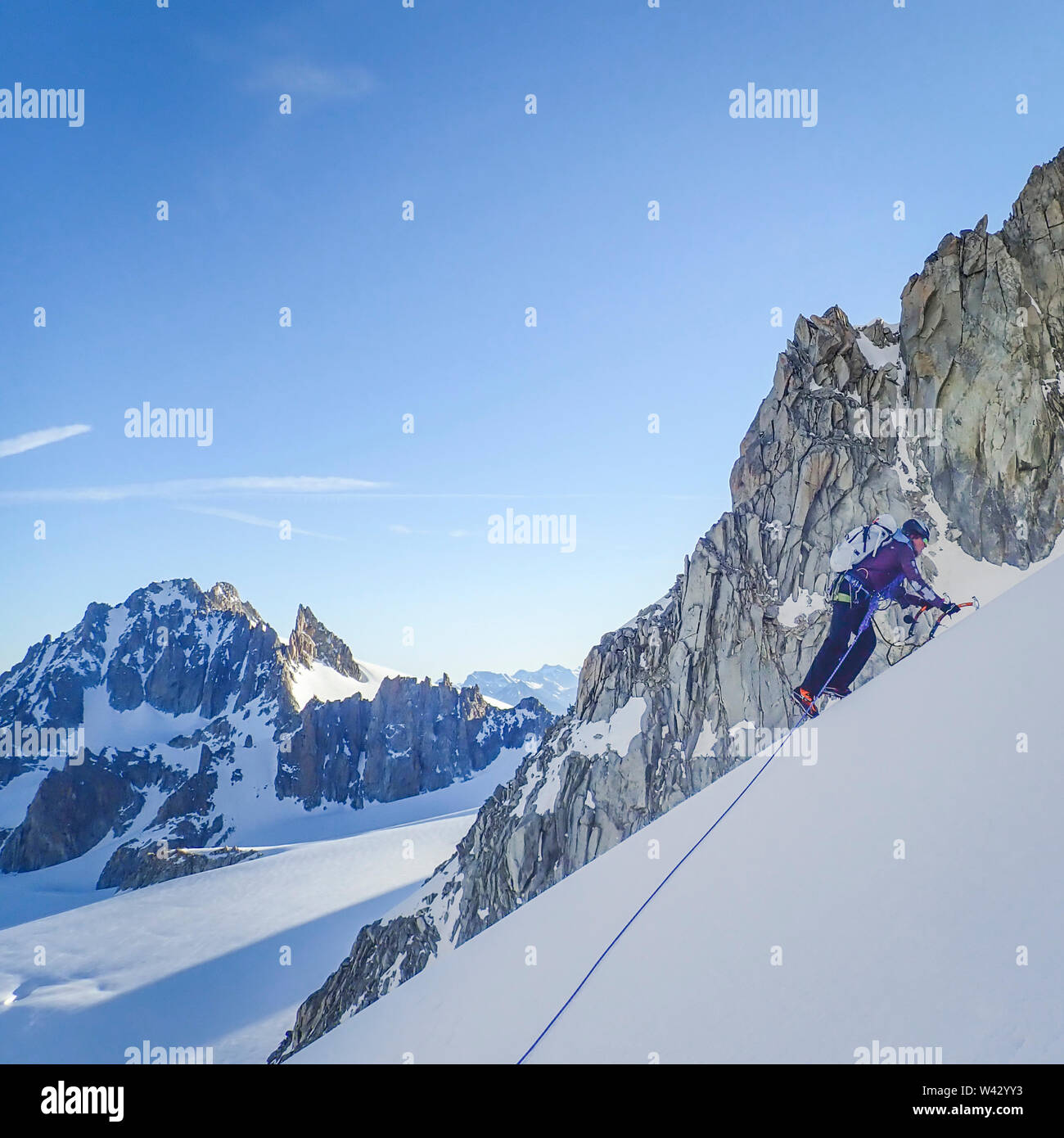 Woman alpinist ascends a snow slope above the Le Tour Glacier Stock Photo