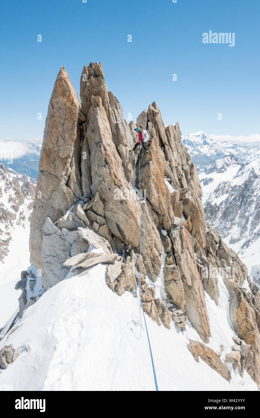 A seasoned alpinist rappels a spectacular gendarme on the Forbes Ridge Stock Photo