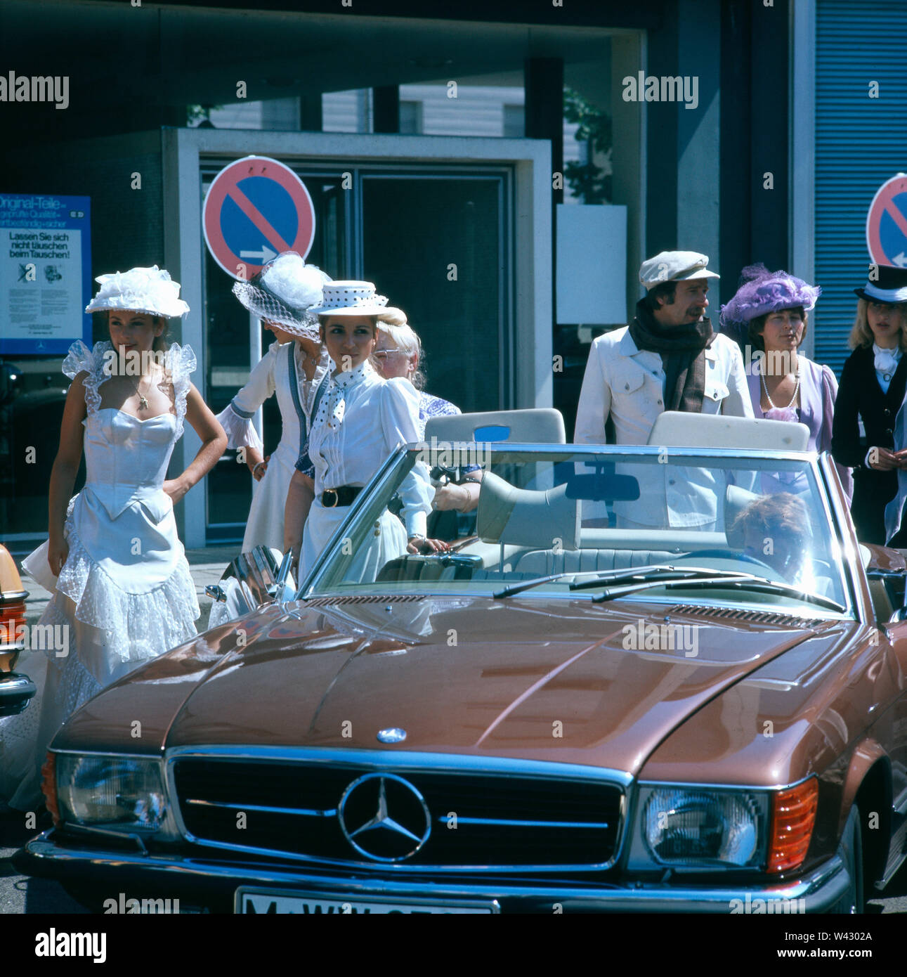 Mehrere Besucher Einer Munchner Autoshow Stehen Neben Einem Mercedes Benz 300 Sl Cabriolet Mit 1986er Baujahr Several Visitors To A Munich Auto Show Stand Next To A Mercedes Benz 300 Sl Cabriolet Built In