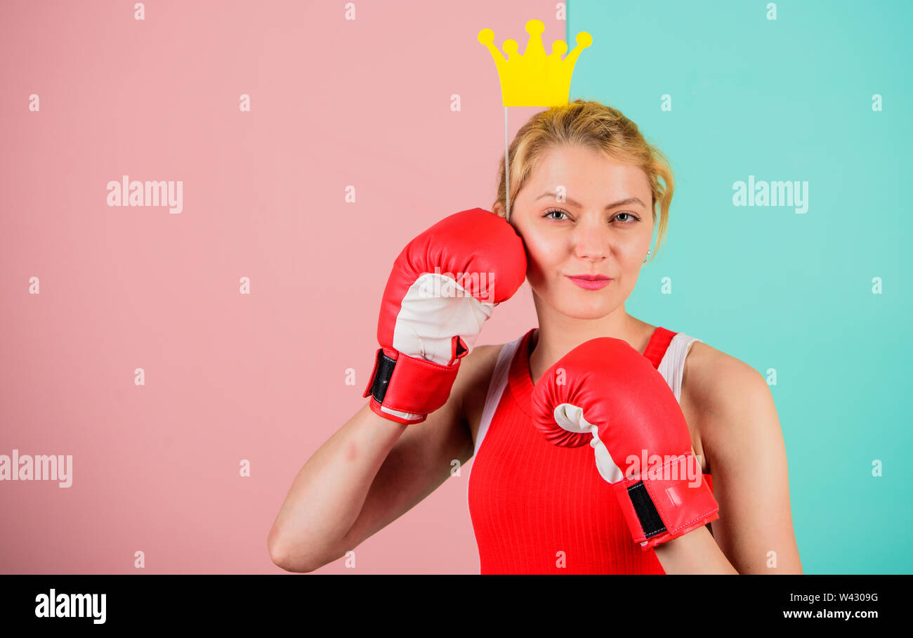 Feminine tender blonde with queen crown wear boxing gloves. Fight for