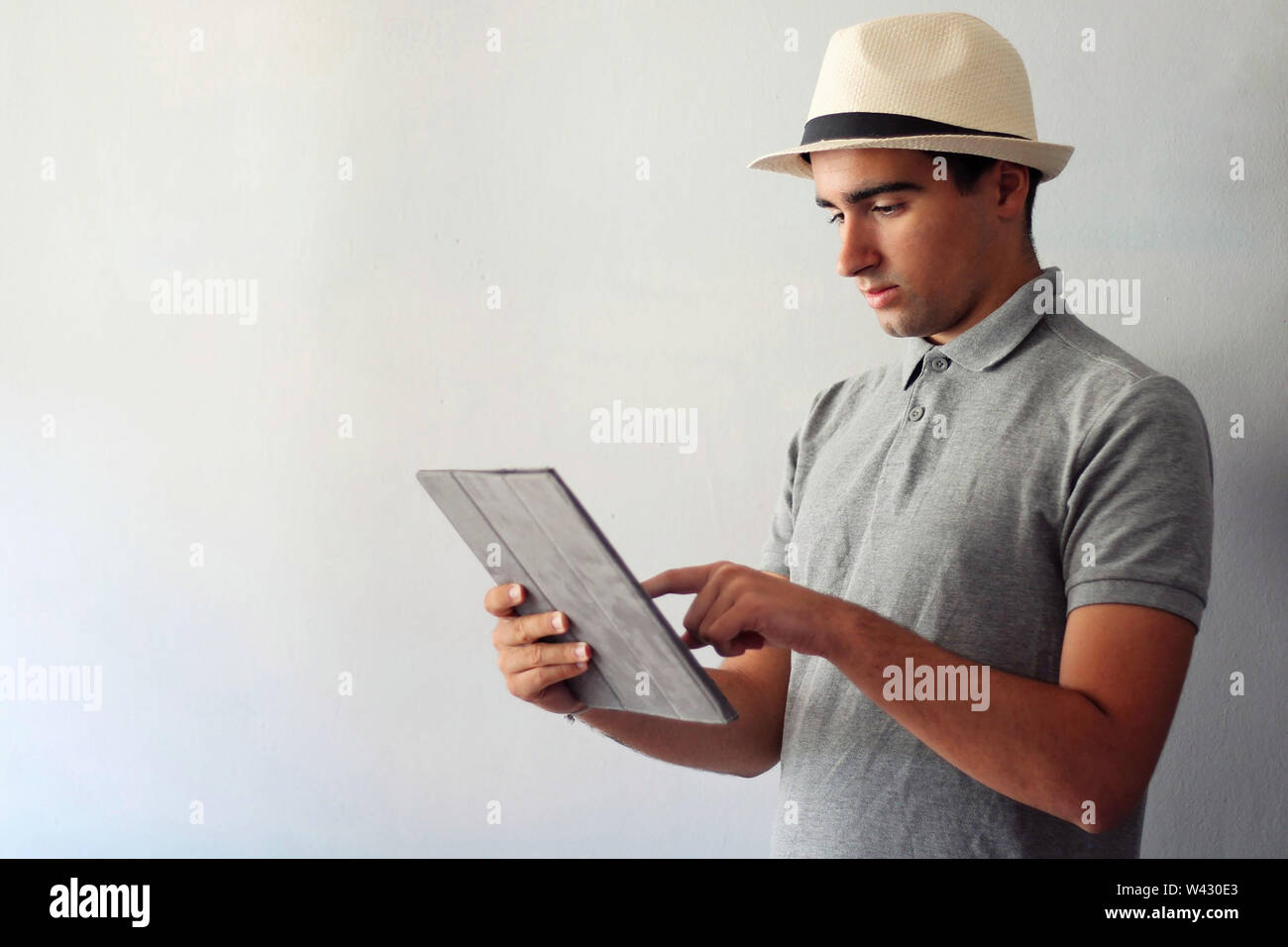 Man dressed in gray using a tablet. Stock Photo